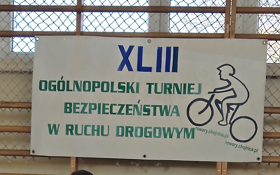 Zdjęcie plakatu XLIII Ogólnopolskiego Turnieju Bezpieczeństwa w Ruchu Drogowym Zawierającego tekst "XLIII OGÓLNOPOLSKI TURNIEJ BEZPIECZEŃSTWA W RUCHU DROGOWYM".